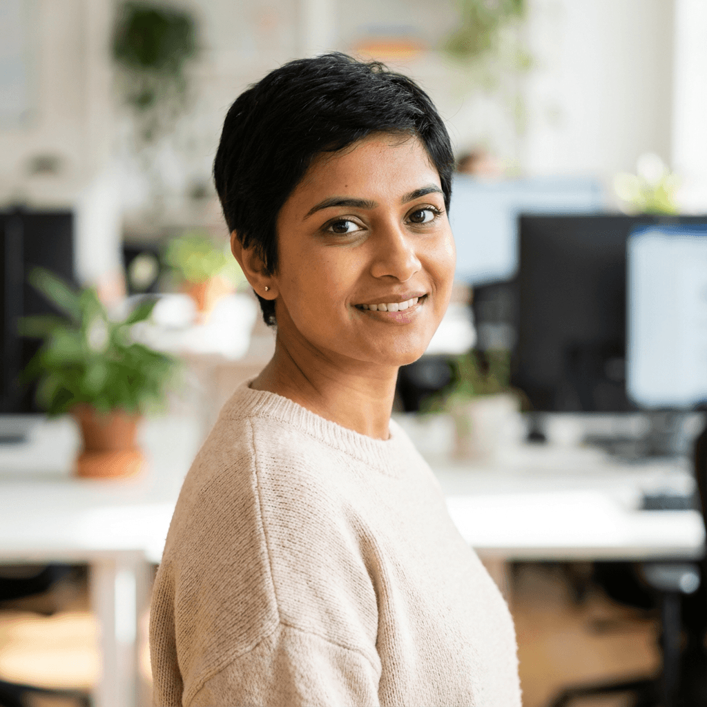 Female South Asian woman in late 20s with relieved expression holding a phone